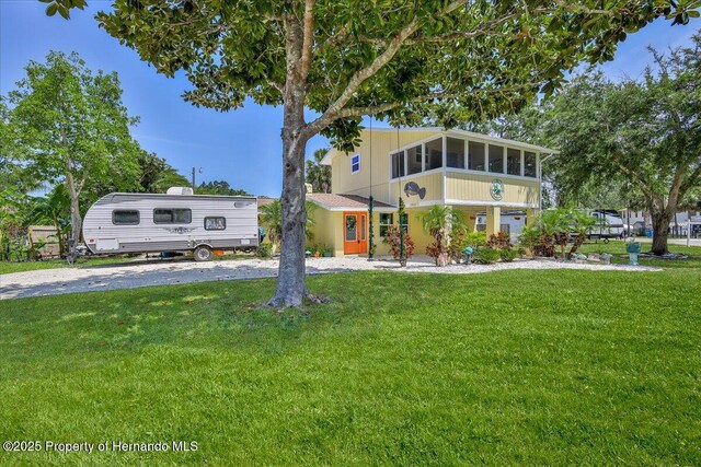 5507 Darlene St, Weeki Wachee, FL 34607 - view of front of property featuring a front lawn and a sunroom