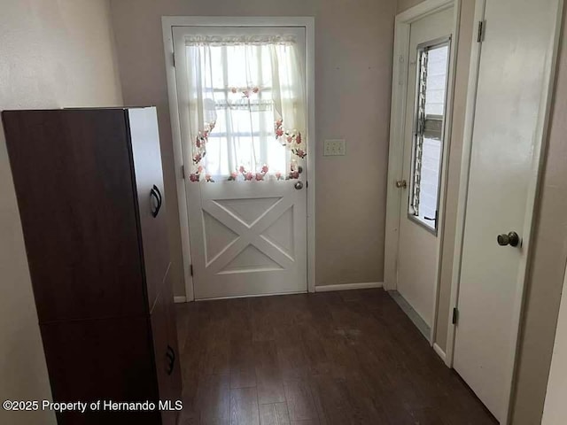 12801 Winding Way, Hudson, FL 34667 - doorway featuring dark wood-style flooring and baseboards