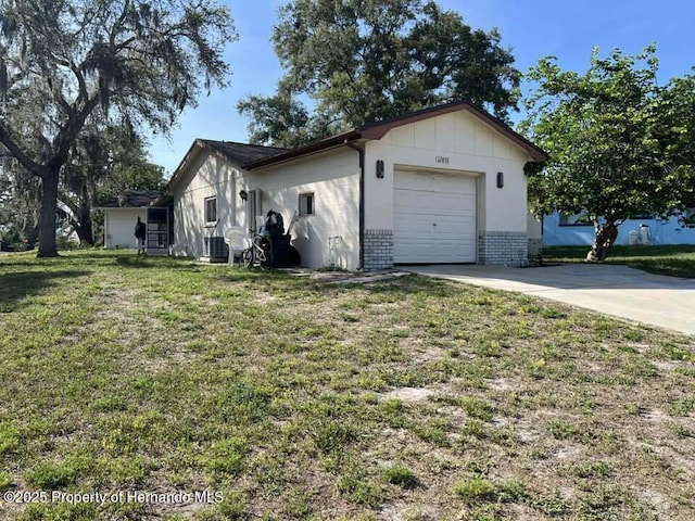 12801 Winding Way, Hudson, FL 34667 - view of home's exterior with concrete driveway, a garage, brick siding, a lawn, and board and batten siding