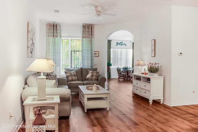 5233 Jennings Trl, Brooksville, FL 34601 - living room with arched walkways, a ceiling fan, wood finished floors, and baseboards