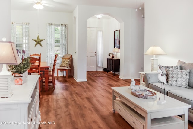 5233 Jennings Trl, Brooksville, FL 34601 - living room featuring arched walkways, light wood-type flooring, a ceiling fan, and baseboards