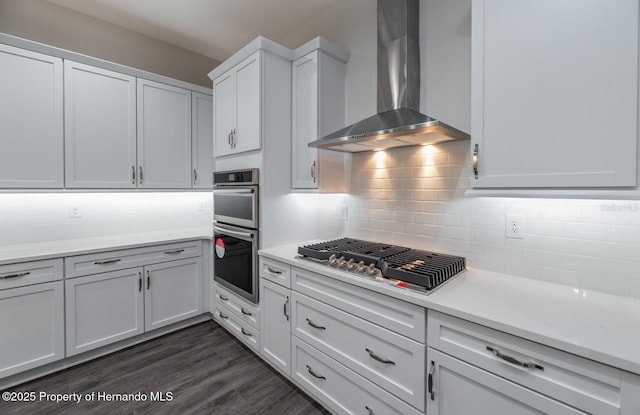 4056 Southern Valley Loop, Brooksville, FL 34601 - kitchen with wall chimney exhaust hood, appliances with stainless steel finishes, light countertops, white cabinets, and decorative backsplash