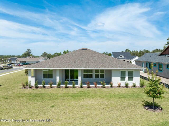 4056 Southern Valley Loop, Brooksville, FL 34601 - rear view of house featuring stucco siding, a yard, and a shingled roof