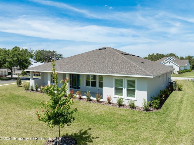 4056 Southern Valley Loop, Brooksville, FL 34601 - back of property featuring a shingled roof, a lawn, and stucco siding