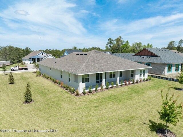 4056 Southern Valley Loop, Brooksville, FL 34601 - rear view of house with roof with shingles and a lawn
