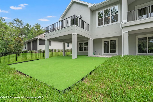 4522 Majestic Hills Loop, Brooksville, FL 34601 - rear view of house with a balcony, a putting green, and stucco siding
