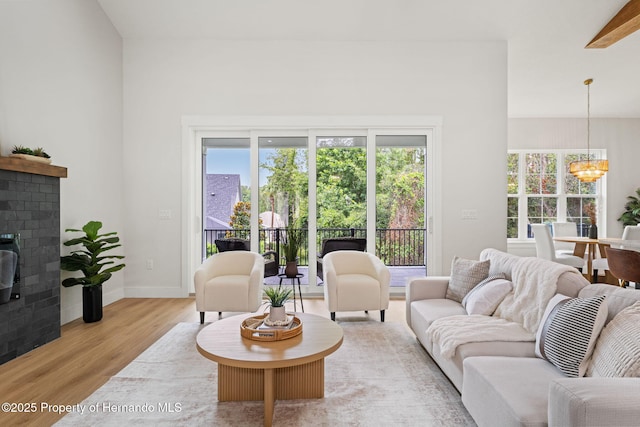 4522 Majestic Hills Loop, Brooksville, FL 34601 - living room with a chandelier, wood finished floors, healthy amount of natural light, and a brick fireplace