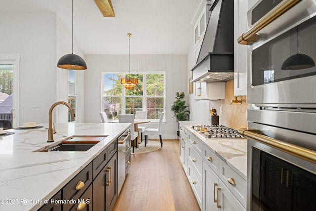 4522 Majestic Hills Loop, Brooksville, FL 34601 - kitchen with stainless steel appliances, a chandelier, white cabinetry, pendant lighting, and light wood-type flooring