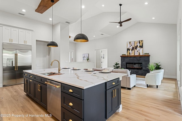 4522 Majestic Hills Loop, Brooksville, FL 34601 - kitchen with appliances with stainless steel finishes, high vaulted ceiling, white cabinets, a center island with sink, and light wood-type flooring