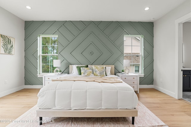 4522 Majestic Hills Loop, Brooksville, FL 34601 - bedroom featuring a decorative wall, light wood-style flooring, recessed lighting, and ensuite bathroom