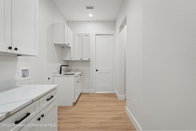 4522 Majestic Hills Loop, Brooksville, FL 34601 - laundry area featuring hookup for a washing machine, light wood-style flooring, electric dryer hookup, recessed lighting, and cabinet space