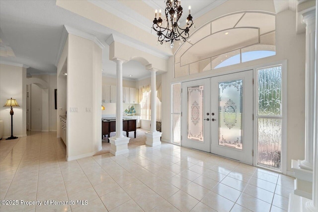 11137 Woodland Waters Blvd, Spring Hill, FL 34613 - entrance foyer with ornate columns, ornamental molding, light tile patterned flooring, french doors, and baseboards