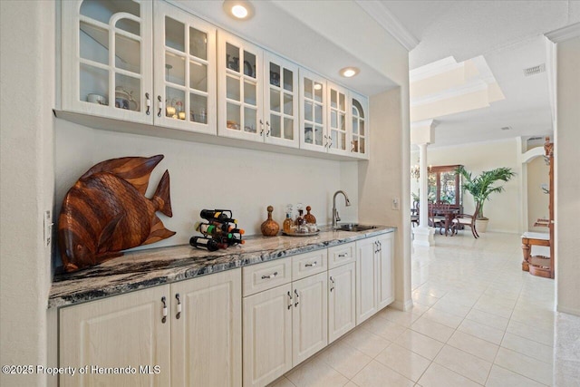 11137 Woodland Waters Blvd, Spring Hill, FL 34613 - bar area featuring a sink, light tile patterned floors, crown molding, decorative columns, and baseboards