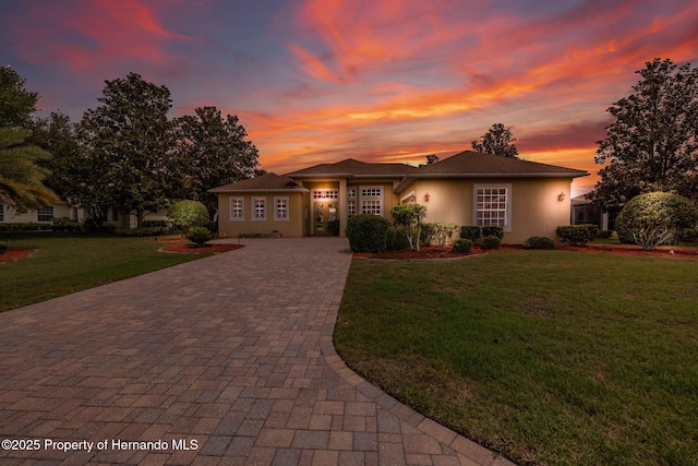 8308 Mobile Cir, Weeki Wachee, FL 34613 - view of front of home featuring decorative driveway, stucco siding, and a yard