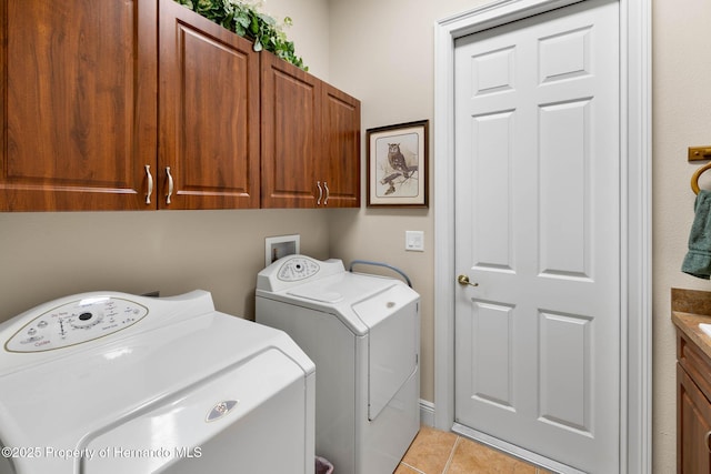 8308 Mobile Cir, Weeki Wachee, FL 34613 - laundry room with washing machine and clothes dryer, cabinet space, and light tile patterned floors
