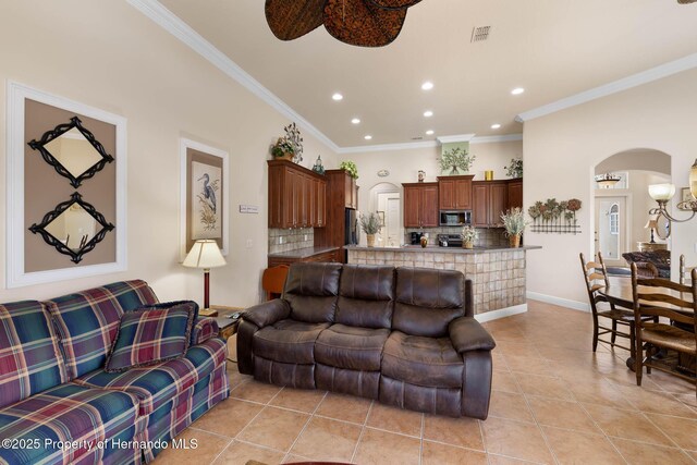 8308 Mobile Cir, Weeki Wachee, FL 34613 - living area featuring arched walkways, light tile patterned floors, recessed lighting, crown molding, and baseboards