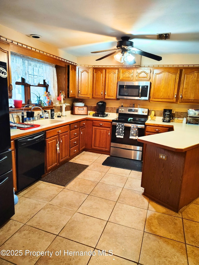 6208 Roble Ave, Spring Hill, FL 34608 - kitchen with stainless steel appliances, light countertops, brown cabinetry, and a ceiling fan