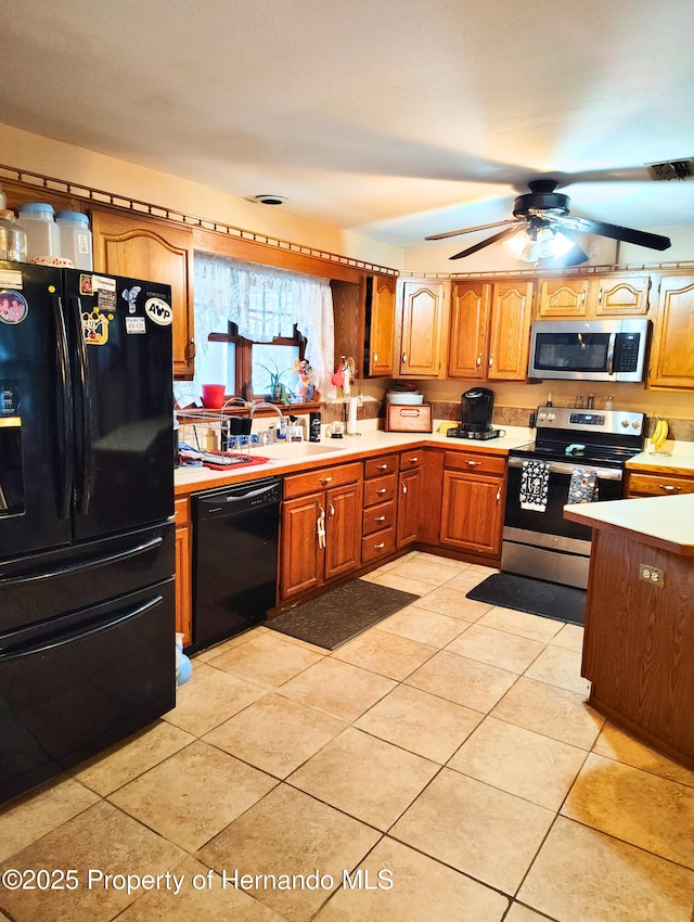 6208 Roble Ave, Spring Hill, FL 34608 - kitchen featuring black appliances, light countertops, ceiling fan, brown cabinetry, and light tile patterned flooring