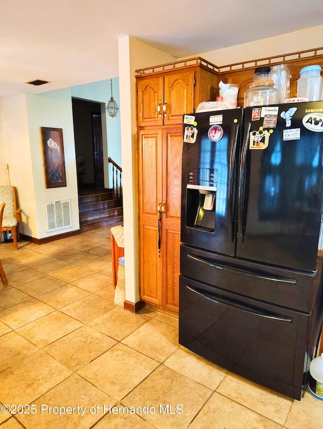 6208 Roble Ave, Spring Hill, FL 34608 - kitchen featuring black fridge with ice dispenser, brown cabinets, and light tile patterned floors