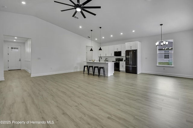 1080 Dunlap Ave, Spring Hill, FL 34609 - unfurnished living room with a ceiling fan, lofted ceiling, baseboards, light wood-style floors, and recessed lighting