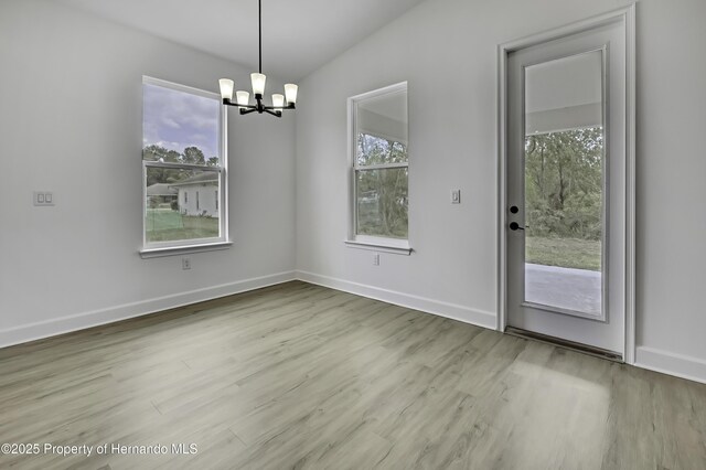 1080 Dunlap Ave, Spring Hill, FL 34609 - unfurnished dining area featuring a chandelier, wood finished floors, and baseboards