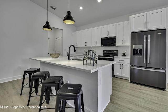 1080 Dunlap Ave, Spring Hill, FL 34609 - kitchen featuring black appliances, a sink, light wood-style floors, white cabinetry, and a kitchen breakfast bar
