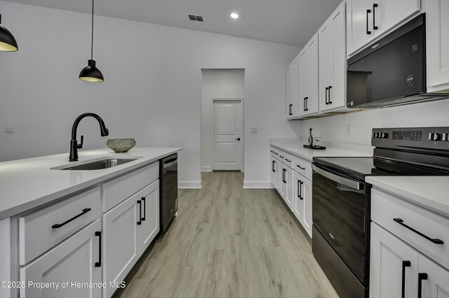 1080 Dunlap Ave, Spring Hill, FL 34609 - kitchen featuring black appliances, a sink, light wood-style flooring, light countertops, and white cabinets