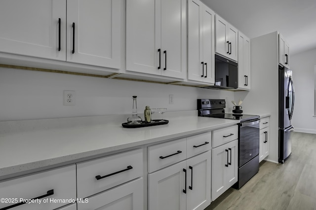 1080 Dunlap Ave, Spring Hill, FL 34609 - kitchen with electric range, fridge with ice dispenser, light wood-style flooring, white cabinets, and baseboards