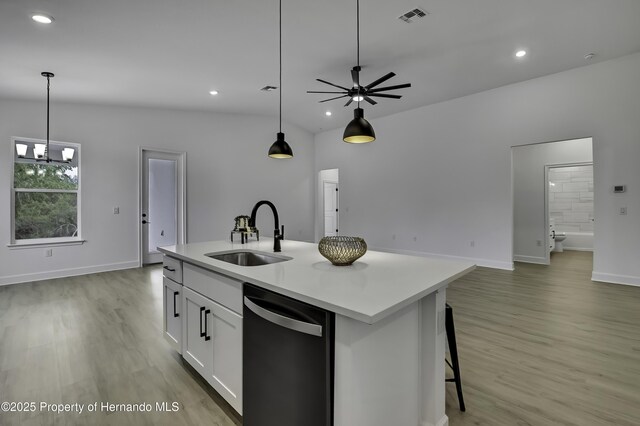 1080 Dunlap Ave, Spring Hill, FL 34609 - kitchen featuring dishwasher, a sink, open floor plan, light wood-style floors, and white cabinets