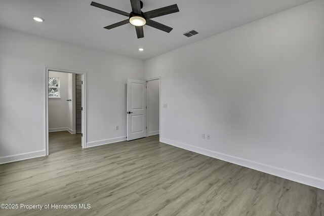1080 Dunlap Ave, Spring Hill, FL 34609 - unfurnished bedroom with baseboards, wood finished floors, recessed lighting, ceiling fan, and a walk in closet