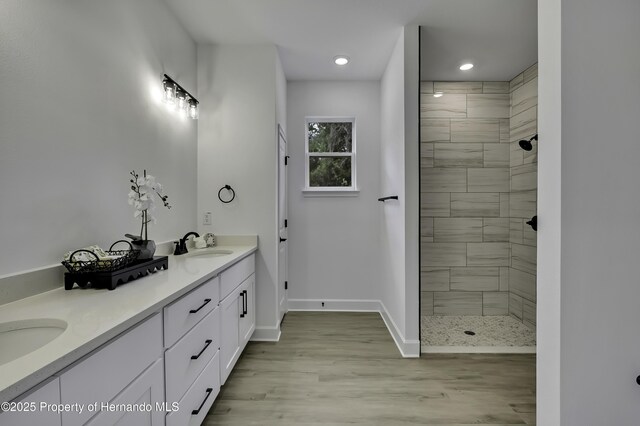 1080 Dunlap Ave, Spring Hill, FL 34609 - bathroom featuring tiled shower, double vanity, wood finished floors, baseboards, and recessed lighting
