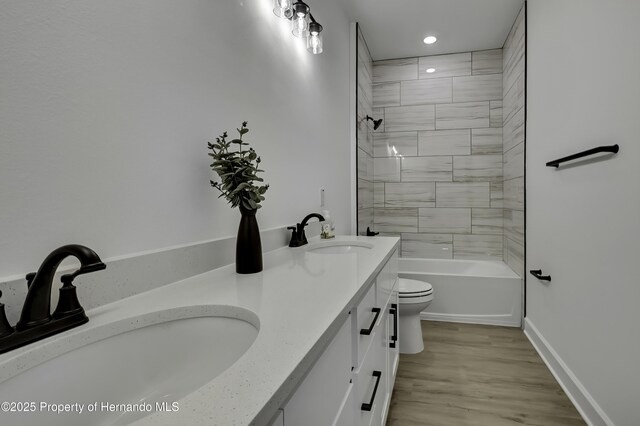 1080 Dunlap Ave, Spring Hill, FL 34609 - bathroom with toilet, recessed lighting, double vanity, wood finished floors, and tub / shower combination