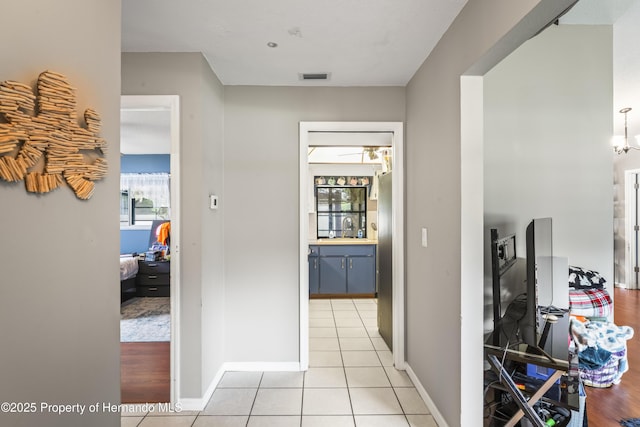 1038 Shenandoah Ln, Spring Hill, FL 34606 - corridor featuring a sink, light tile patterned floors, and baseboards