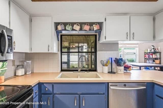 1038 Shenandoah Ln, Spring Hill, FL 34606 - kitchen featuring dishwasher, blue cabinets, a sink, and light countertops