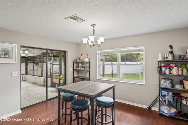 1038 Shenandoah Ln, Spring Hill, FL 34606 - dining room featuring a chandelier, wood finished floors, a textured ceiling, and baseboards