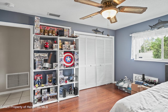 1038 Shenandoah Ln, Spring Hill, FL 34606 - bedroom featuring a closet, a textured ceiling, ceiling fan, and wood finished floors