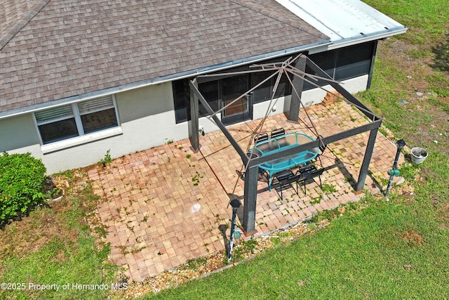 1038 Shenandoah Ln, Spring Hill, FL 34606 - view of property exterior with a shingled roof, a patio, and stucco siding