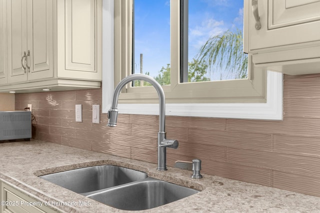 4523 Gulfstream Dr, Hernando Beach, FL 34607 - kitchen view of a sink, decorative backsplash, and cream cabinetry
