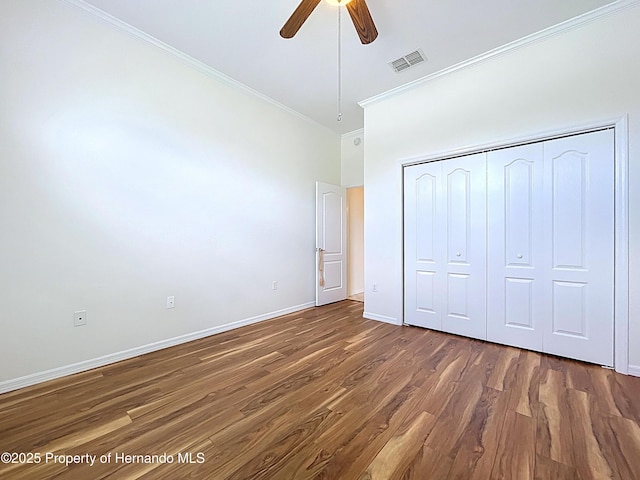 13417 Whitehaven Ct, Spring Hill, FL 34609 - unfurnished bedroom featuring crown molding, wood finished floors, baseboards, a closet, and ceiling fan