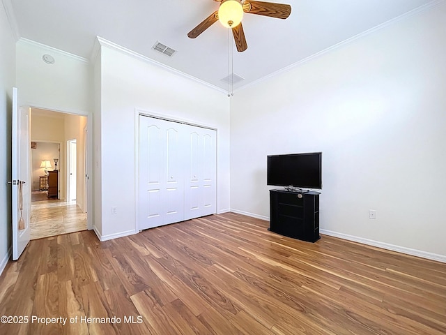 13417 Whitehaven Ct, Spring Hill, FL 34609 - unfurnished bedroom featuring ornamental molding, a towering ceiling, baseboards, wood finished floors, and a closet