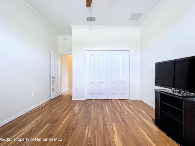 13417 Whitehaven Ct, Spring Hill, FL 34609 - unfurnished bedroom featuring crown molding, baseboards, wood finished floors, a closet, and ceiling fan