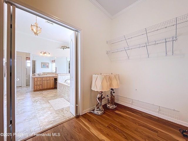 13417 Whitehaven Ct, Spring Hill, FL 34609 - laundry area featuring ornamental molding, a chandelier, light wood-style floors, and baseboards