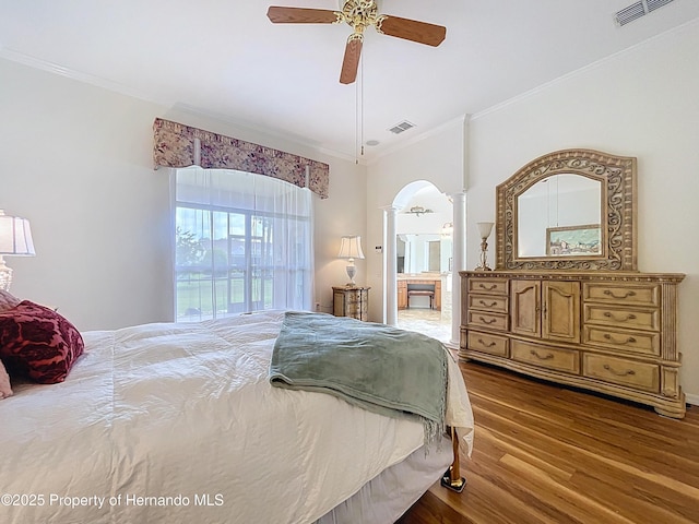 13417 Whitehaven Ct, Spring Hill, FL 34609 - bedroom with ornate columns, arched walkways, crown molding, wood finished floors, and ensuite bathroom