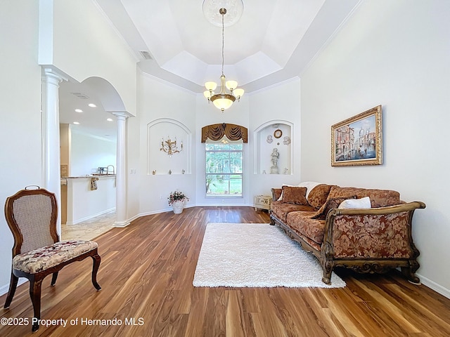 13417 Whitehaven Ct, Spring Hill, FL 34609 - living area featuring ornate columns, wood finished floors, a raised ceiling, baseboards, and arched walkways