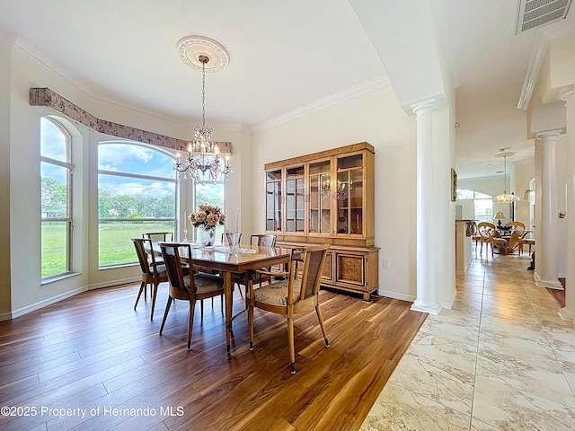 13417 Whitehaven Ct, Spring Hill, FL 34609 - dining room featuring ornate columns, healthy amount of natural light, a chandelier, crown molding, and baseboards