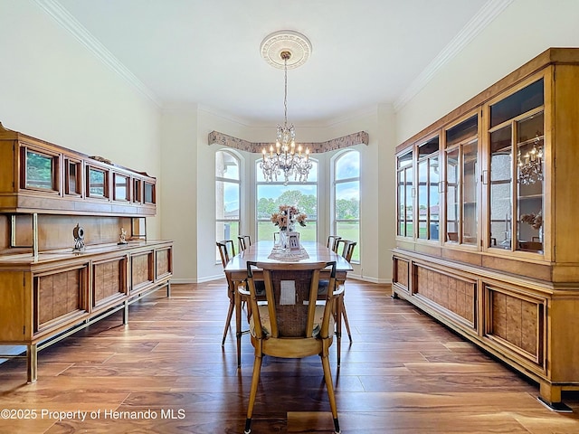 13417 Whitehaven Ct, Spring Hill, FL 34609 - dining area with a chandelier, crown molding, wood finished floors, and baseboards