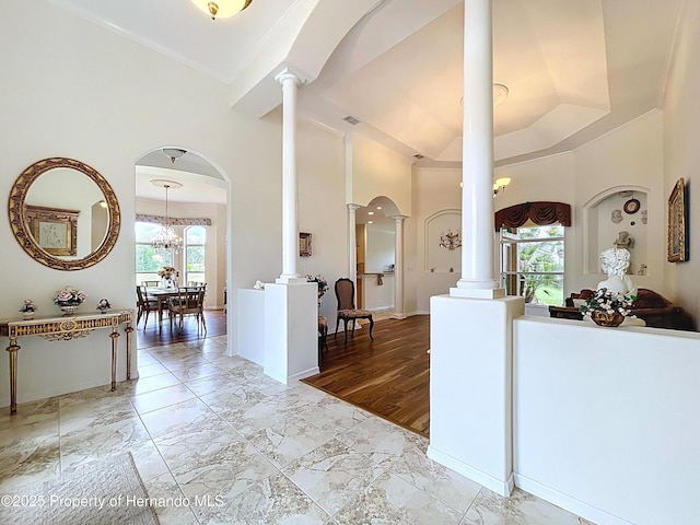 13417 Whitehaven Ct, Spring Hill, FL 34609 - entrance foyer with ornate columns, a high ceiling, baseboards, marble finish flooring, and arched walkways
