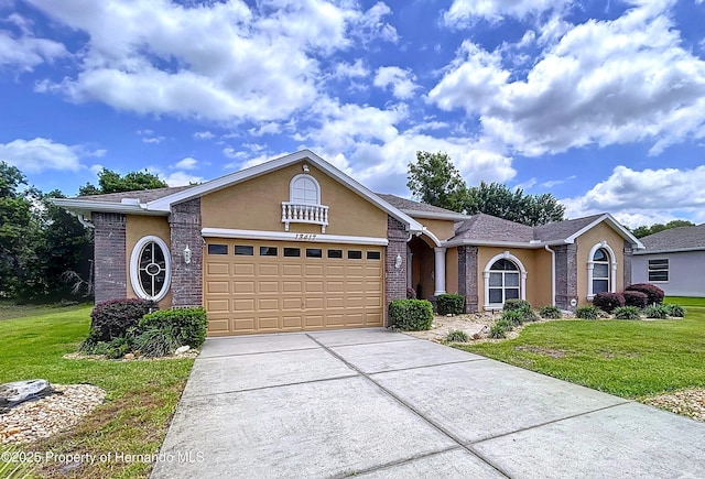 13417 Whitehaven Ct, Spring Hill, FL 34609 - view of front facade featuring a front yard, an attached garage, driveway, and stucco siding