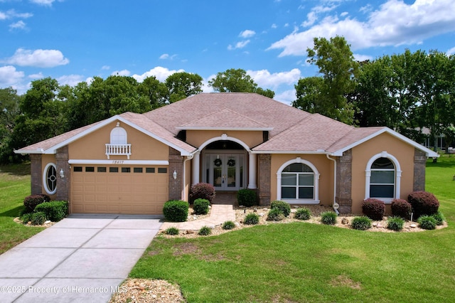 13417 Whitehaven Ct, Spring Hill, FL 34609 - mediterranean / spanish house with french doors, a front lawn, a garage, driveway, and stucco siding