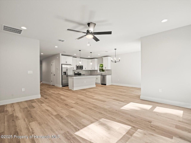 14448 Chimney Swift Rd, Weeki Wachee, FL 34614 - unfurnished living room with a chandelier, a ceiling fan, recessed lighting, light wood-style flooring, and baseboards